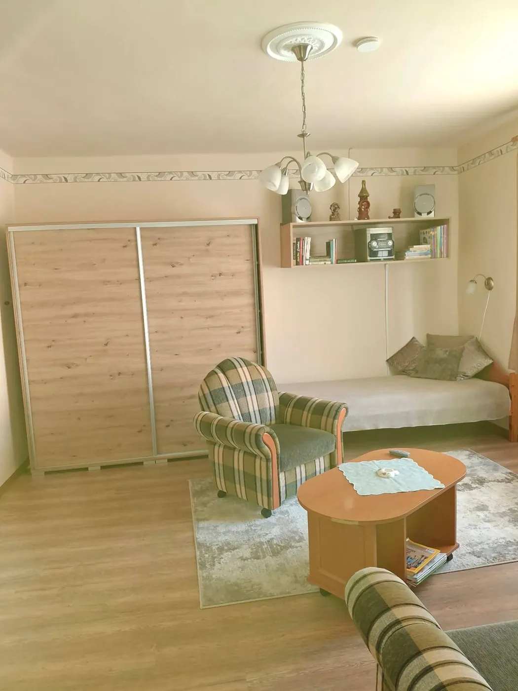 A másik szoba tolóajtós szekrénnyel, fotellel és heverővel